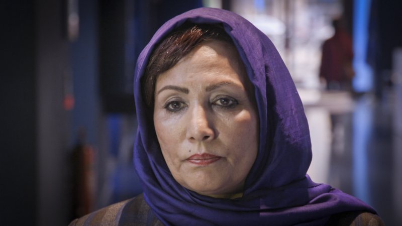 woman with purple head scarf looking pensive